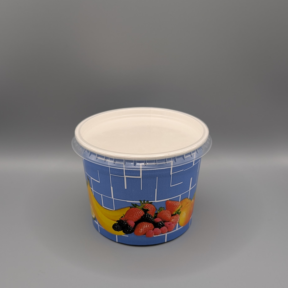 580-ml-Pappbecher mit blauem Früchtemotiv und transparentem Deckel, schräge Ansicht