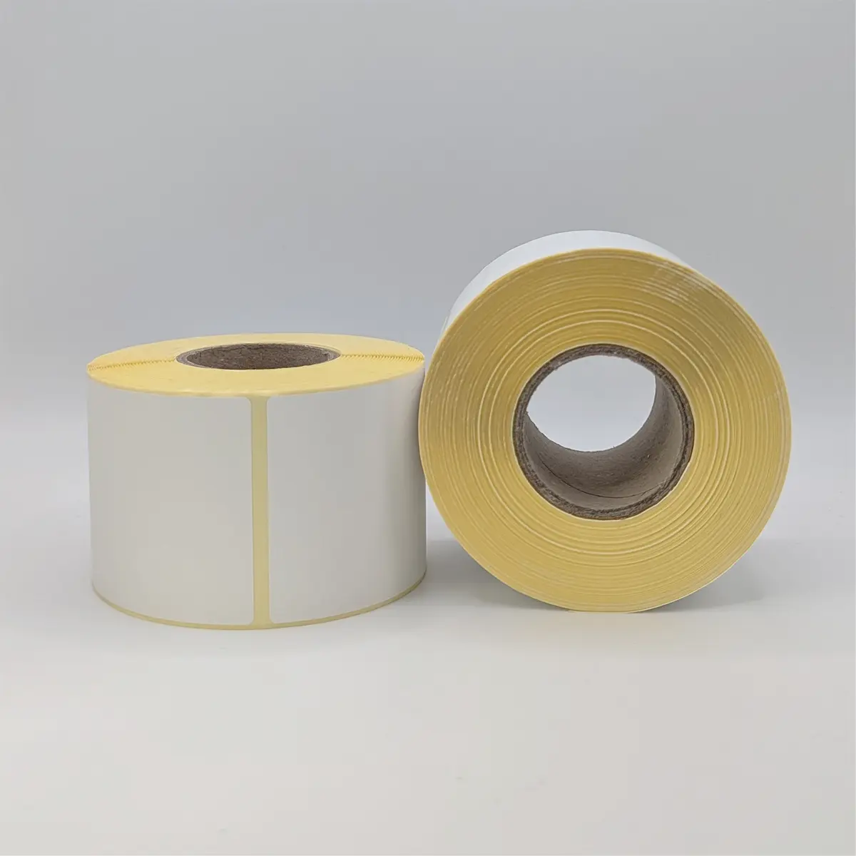 Etikettenrolle mit 58 x 101 mm Etiketten auf gelbem Trägerpapier gestapelt Etikettenrolle mit 58 x 101 mm Etiketten auf gelbem Trägerpapier gestapelt