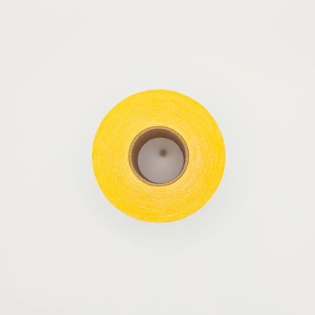 Etikettenrolle mit 58 x 53 mm Etiketten auf gelbem Trägerpapier von der Seite mit Kern