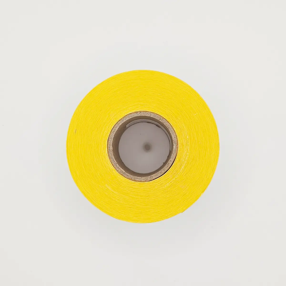 Etikettenrolle mit 58 x 43 mm Etiketten auf gelbem Trägerpapier von der Seite mit KernEtikettenrolle mit 58 x 43 mm Etiketten auf gelbem Trägerpapier von der Seite mit Kern^