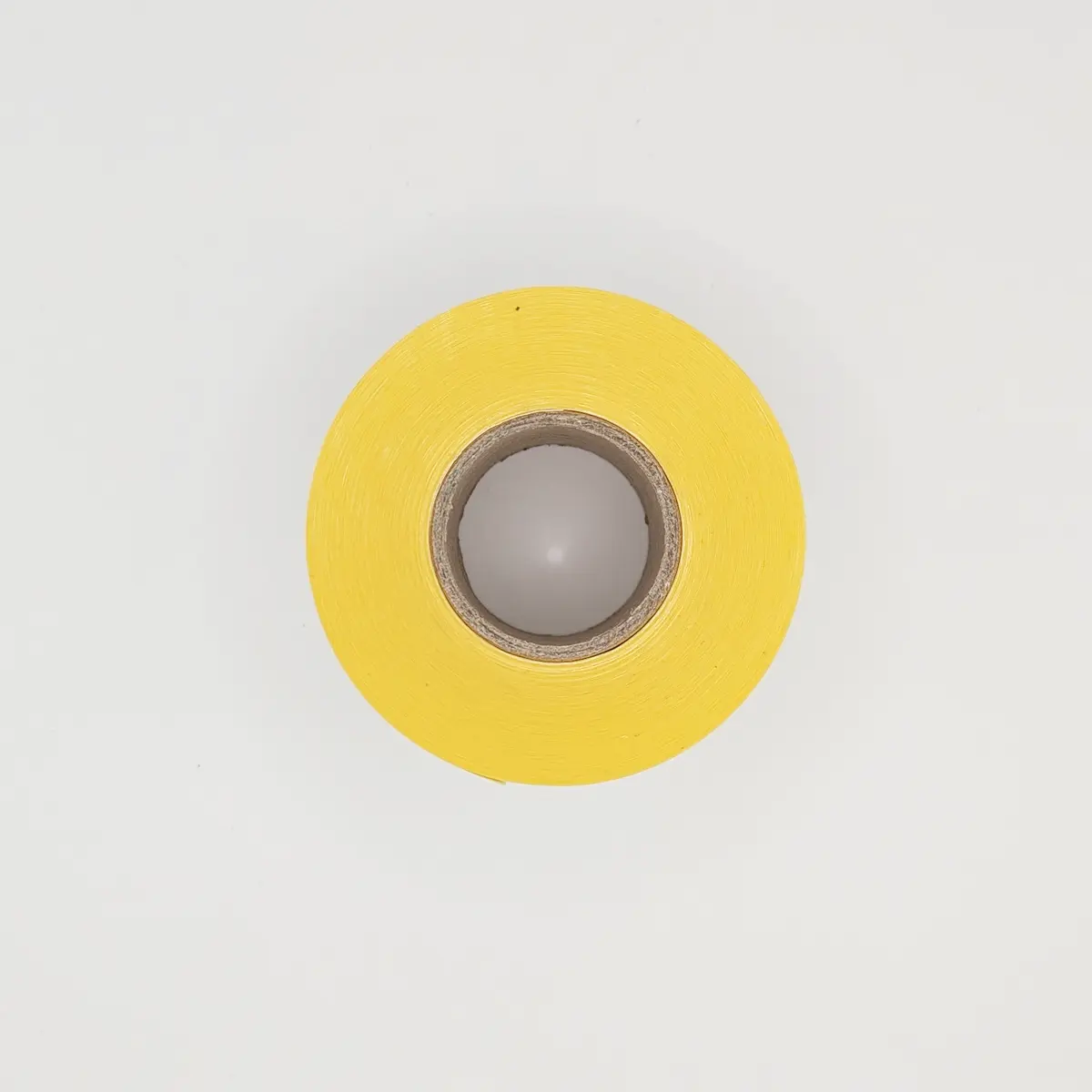 Etikettenrolle mit 58 x 101 mm Etiketten auf gelbem Trägerpapier von der Seite mit Kern Etikettenrolle mit 58 x 101 mm Etiketten auf gelbem Trägerpapier von der Seite mit Kern